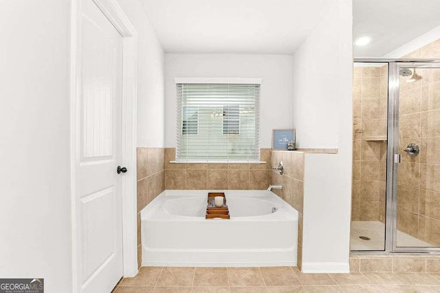 bathroom with shower with separate bathtub and tile patterned floors