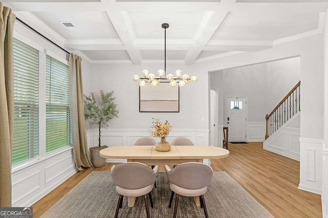 dining room with coffered ceiling, a notable chandelier, beamed ceiling, and light hardwood / wood-style flooring