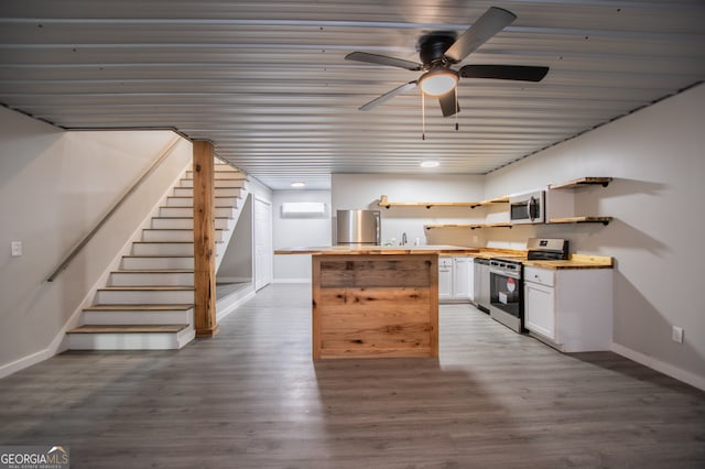 kitchen featuring stainless steel appliances, a wall mounted AC, ceiling fan, white cabinets, and dark hardwood / wood-style floors