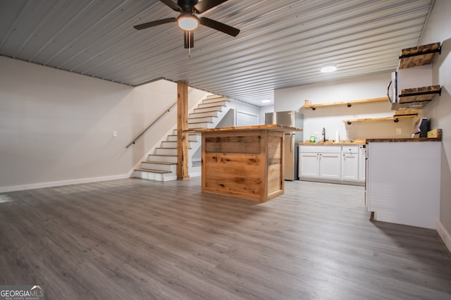 unfurnished living room with hardwood / wood-style floors, ceiling fan, and sink