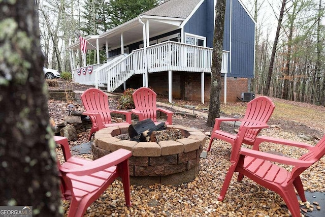 rear view of property featuring a fire pit