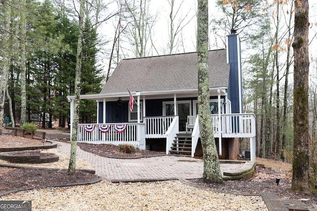 back of house with a wooden deck and a fire pit