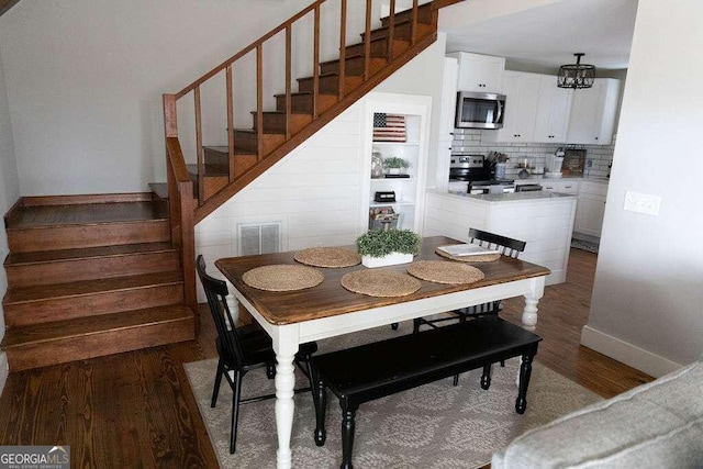 kitchen with appliances with stainless steel finishes, decorative light fixtures, white cabinetry, sink, and backsplash