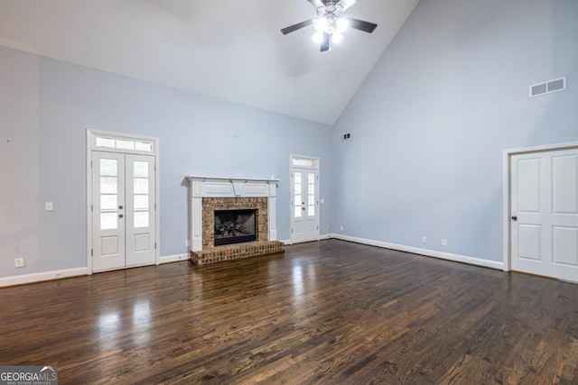 unfurnished living room with plenty of natural light, dark wood-type flooring, and high vaulted ceiling