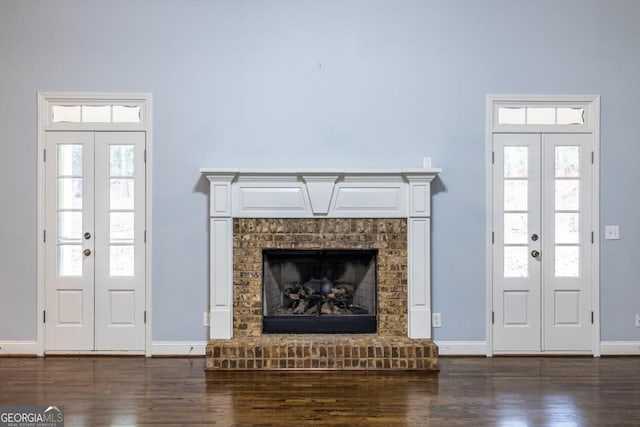 entryway featuring a wealth of natural light, dark wood-type flooring, and a brick fireplace