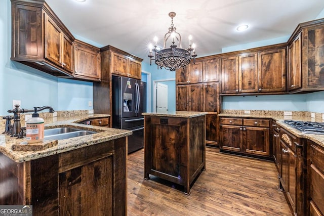 kitchen featuring a center island, sink, stainless steel appliances, hardwood / wood-style floors, and a chandelier