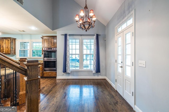 entryway featuring dark hardwood / wood-style floors, high vaulted ceiling, a healthy amount of sunlight, and a notable chandelier