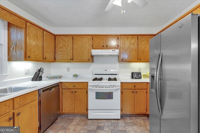 kitchen featuring appliances with stainless steel finishes, a textured ceiling, ceiling fan, and sink