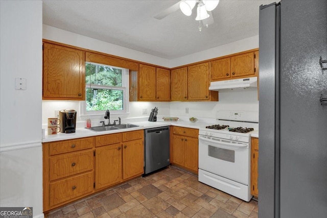 kitchen with ceiling fan, sink, a textured ceiling, and appliances with stainless steel finishes