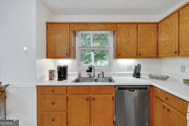 kitchen with sink, stainless steel dishwasher, and a textured ceiling