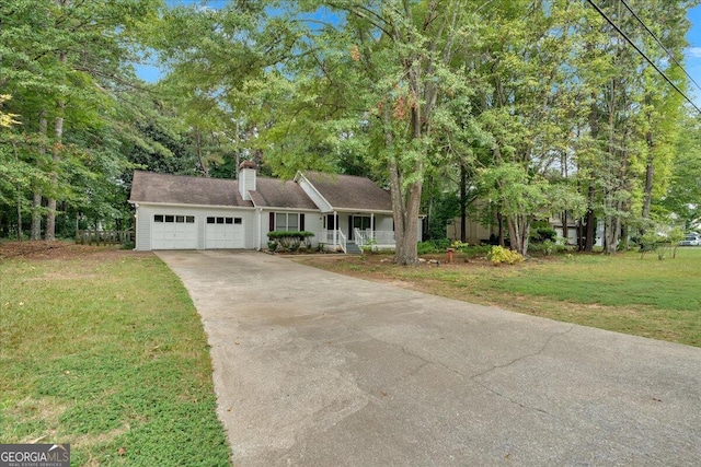 view of front of house featuring covered porch, a garage, and a front lawn