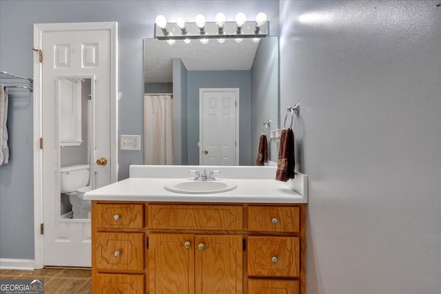 bathroom with tile patterned flooring, vanity, and toilet