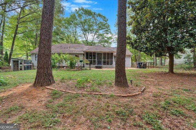 rear view of house featuring a sunroom and a yard