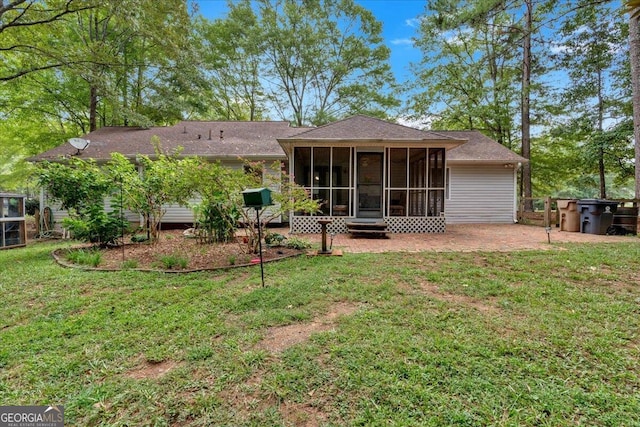 back of property with a sunroom, a patio area, and a lawn