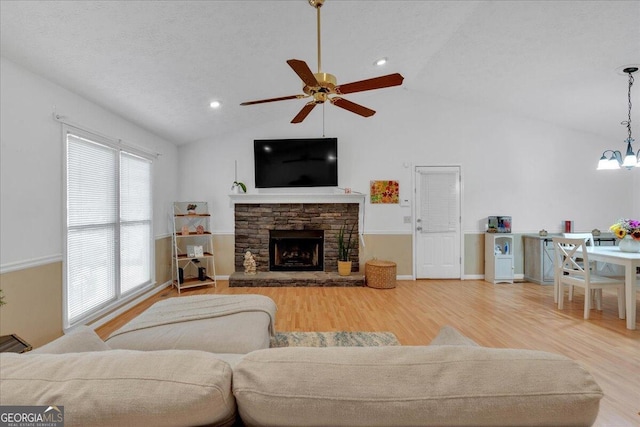 living room featuring wood-type flooring, vaulted ceiling, and a healthy amount of sunlight