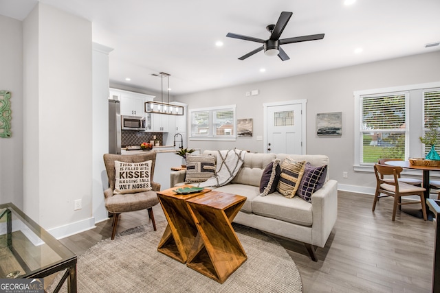 living room featuring light hardwood / wood-style flooring, ceiling fan, a healthy amount of sunlight, and sink