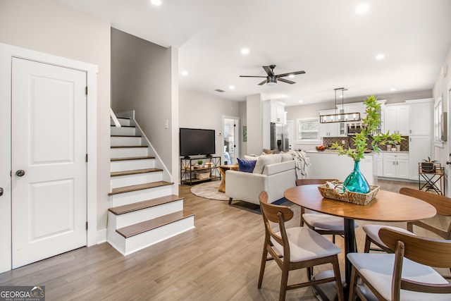 dining area with ceiling fan and light wood-type flooring