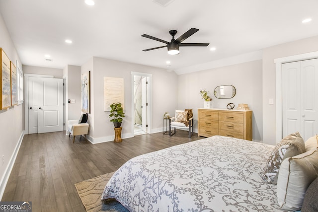 bedroom with ensuite bath, ceiling fan, and dark hardwood / wood-style flooring