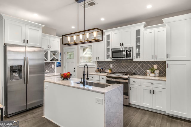 kitchen featuring white cabinetry, sink, dark hardwood / wood-style floors, decorative light fixtures, and appliances with stainless steel finishes