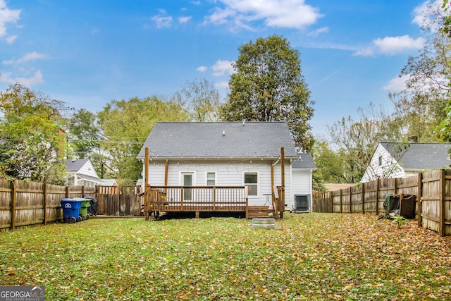 rear view of property featuring a lawn, a wooden deck, and central AC unit