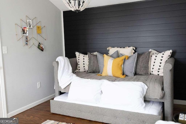 bedroom with dark hardwood / wood-style floors and an inviting chandelier