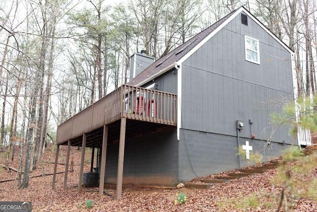 view of side of property with a wooden deck and central AC unit