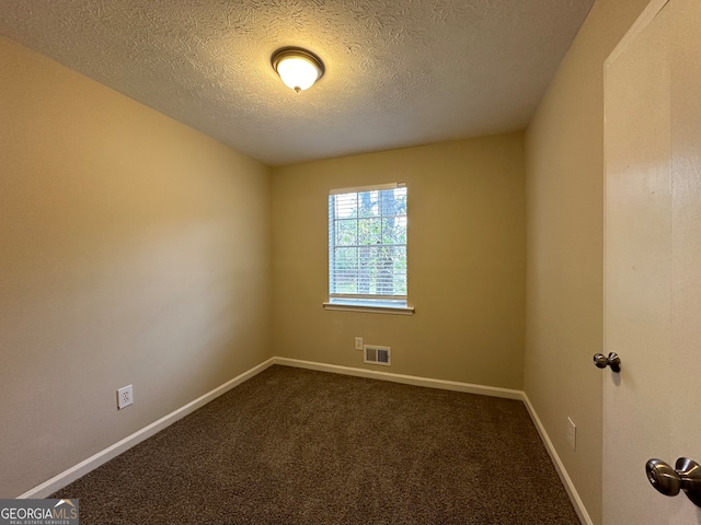 unfurnished room with carpet flooring and a textured ceiling