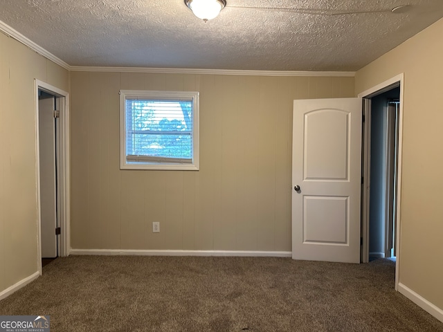 carpeted empty room featuring a textured ceiling and ornamental molding