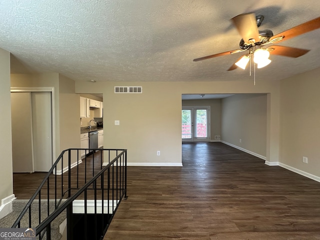 unfurnished room with dark hardwood / wood-style floors, ceiling fan, sink, and a textured ceiling