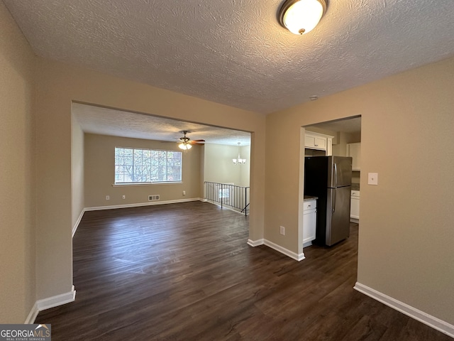 unfurnished living room with dark hardwood / wood-style floors, ceiling fan, and a textured ceiling