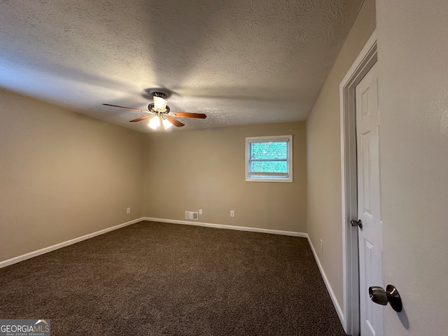 unfurnished room with ceiling fan, dark carpet, and a textured ceiling