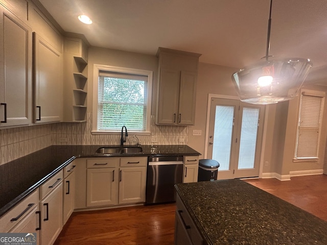 kitchen featuring dark stone counters, sink, hanging light fixtures, stainless steel dishwasher, and decorative backsplash