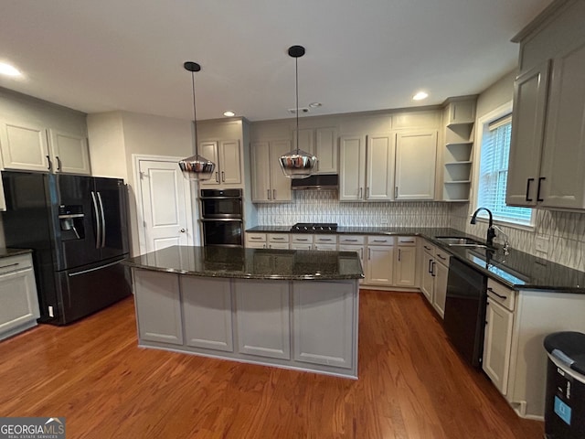 kitchen with sink, dark hardwood / wood-style floors, decorative light fixtures, a kitchen island, and black appliances