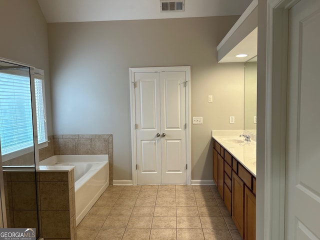 bathroom featuring tile patterned flooring, vanity, and a bathing tub