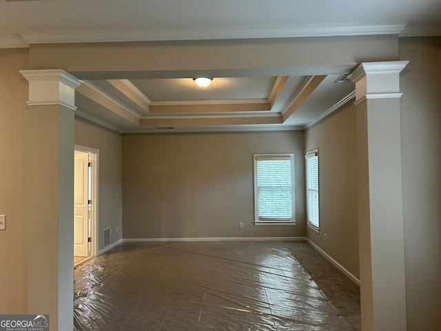 empty room featuring a tray ceiling, ornate columns, and crown molding