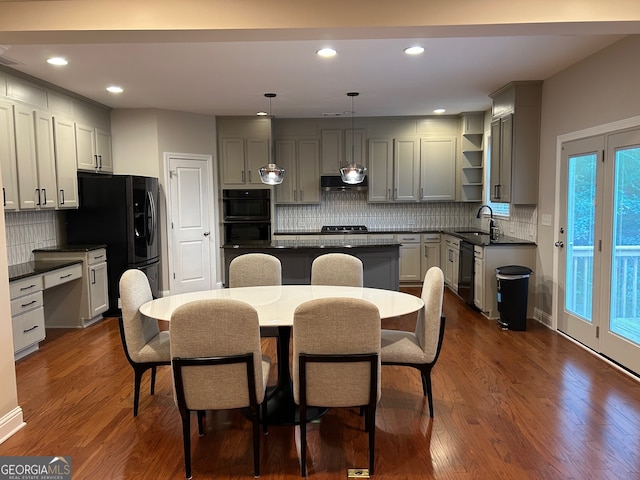 kitchen featuring gray cabinetry, pendant lighting, a center island, sink, and dark hardwood / wood-style floors