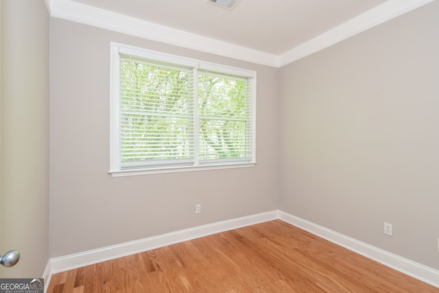 unfurnished room featuring hardwood / wood-style floors and ornamental molding