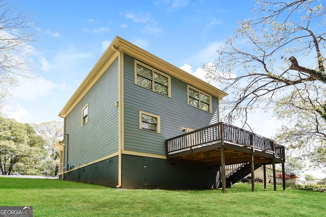 rear view of house featuring a deck and a lawn