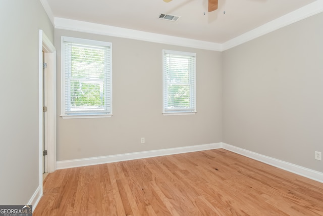 empty room with crown molding, plenty of natural light, ceiling fan, and light hardwood / wood-style flooring