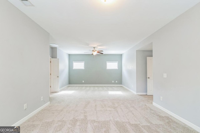 empty room featuring ceiling fan and light colored carpet