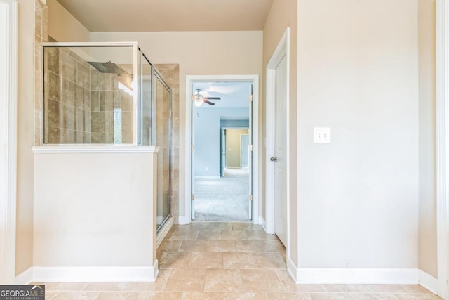 bathroom featuring ceiling fan and a shower with door