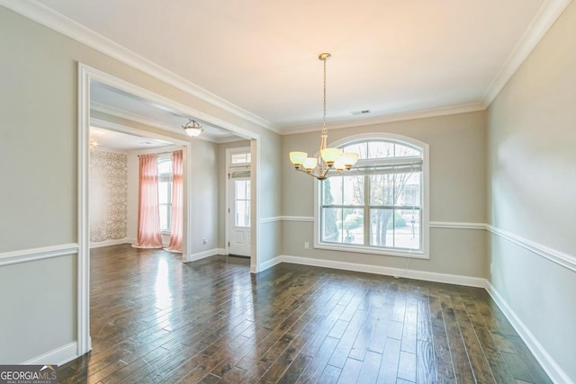 spare room with crown molding, dark hardwood / wood-style flooring, and an inviting chandelier