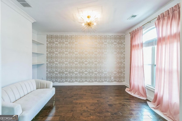 living area with built in shelves, dark hardwood / wood-style floors, ornamental molding, and a chandelier