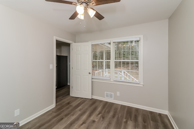 spare room with ceiling fan and dark wood-type flooring