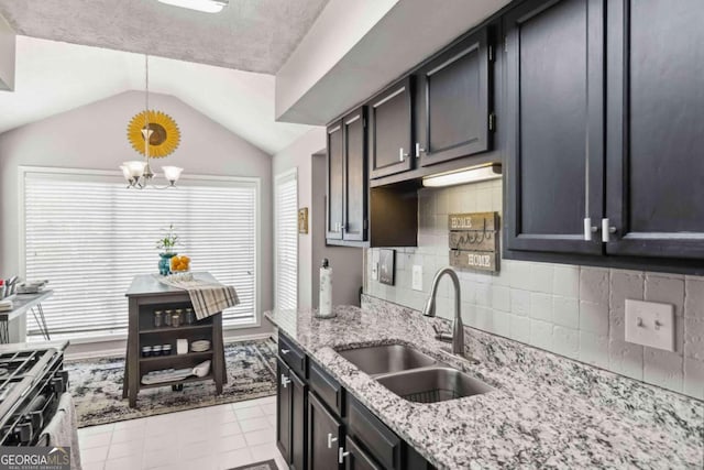 kitchen with sink, vaulted ceiling, decorative backsplash, decorative light fixtures, and a chandelier