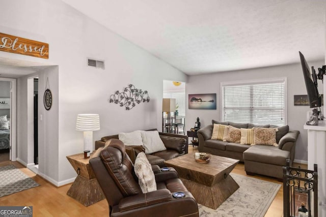 living room with light hardwood / wood-style floors and lofted ceiling