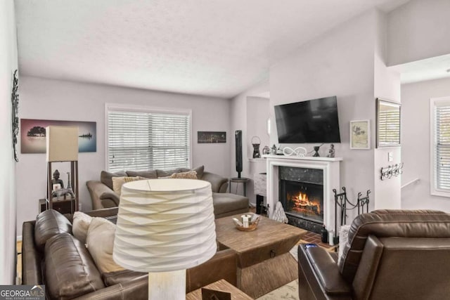 living room with a textured ceiling, lofted ceiling, and a fireplace