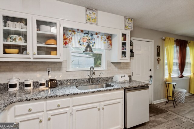 kitchen featuring dishwasher, a healthy amount of sunlight, white cabinetry, and sink