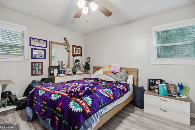 bedroom featuring a textured ceiling, light hardwood / wood-style floors, and ceiling fan