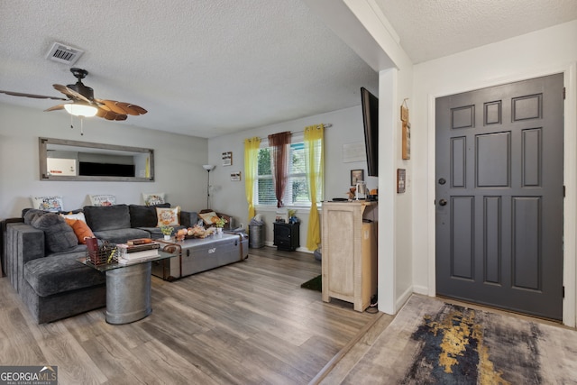 entrance foyer with hardwood / wood-style floors, ceiling fan, and a textured ceiling